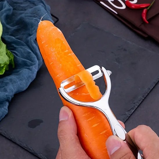 Éplucheur à légumes et sa lame tranchante épluche une carotte