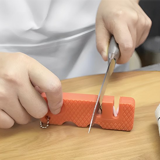 femme aiguise le couteau avec affuteur de couteaux orange